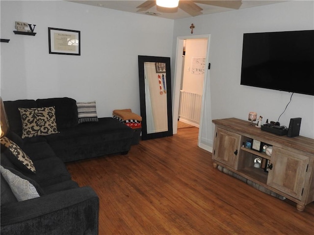 living room with ceiling fan and dark wood-type flooring