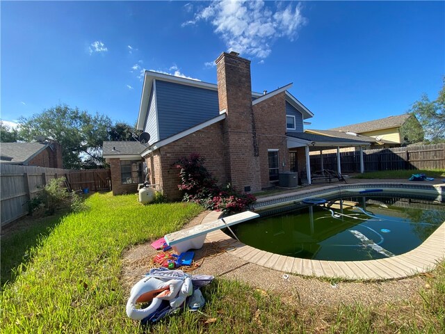 back of house featuring a fenced in pool and central AC