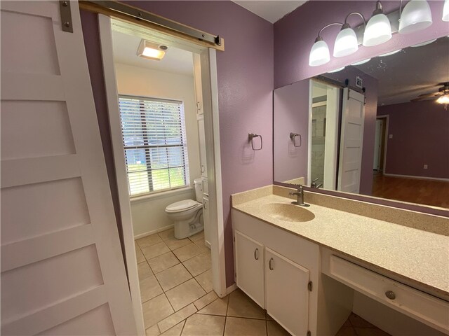 bathroom with tile patterned flooring, vanity, and toilet