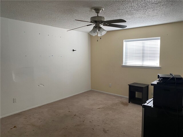 spare room featuring a textured ceiling, light colored carpet, and ceiling fan