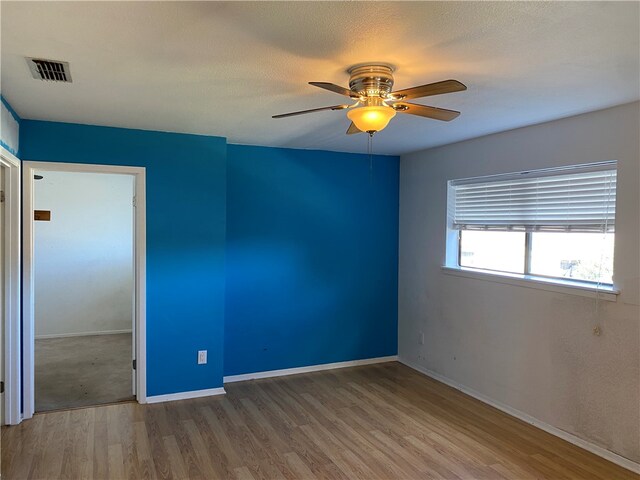 spare room with ceiling fan, hardwood / wood-style floors, and a textured ceiling