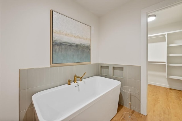416 E Ave C Ave, Port Aransas, TX 78373 - full bath featuring wood finished floors, a freestanding bath, and wainscoting