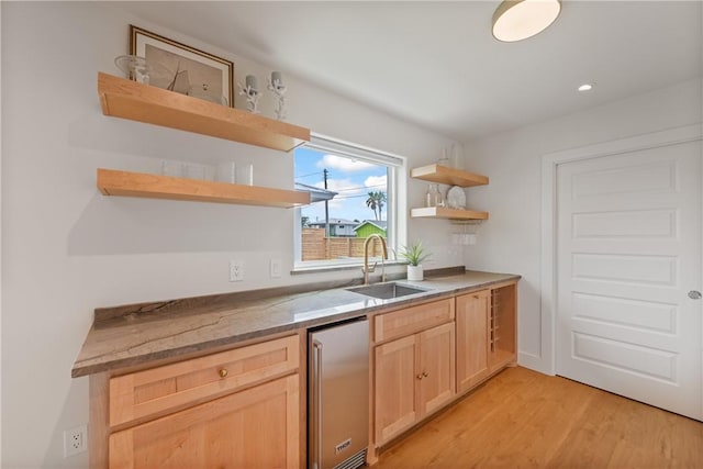 416 E Ave C Ave, Port Aransas, TX 78373 - kitchen with open shelves, a sink, light brown cabinetry, stainless steel refrigerator, and light wood-style flooring