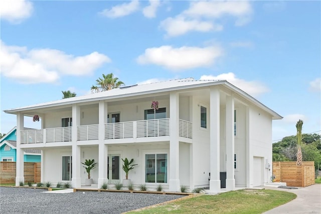 416 E Ave C Ave, Port Aransas, TX 78373 - view of front of house with concrete driveway, a balcony, an attached garage, and stucco siding