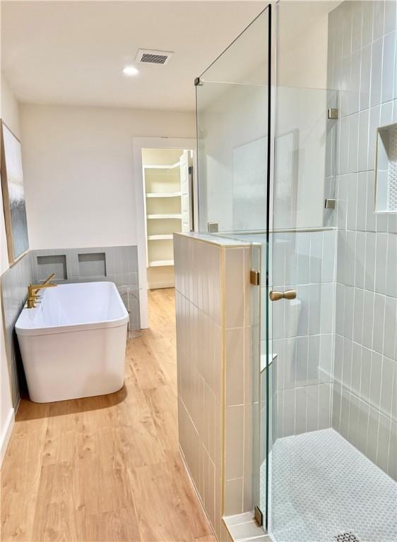 416 E Ave C Ave, Port Aransas, TX 78373 - bathroom with wood finished floors, a stall shower, a freestanding tub, and recessed lighting
