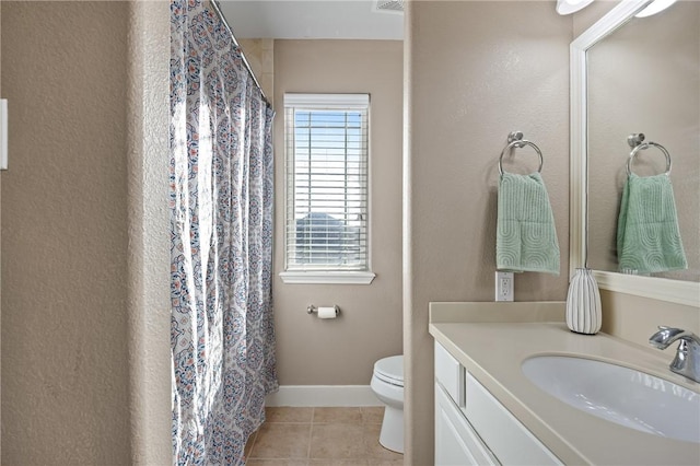 bathroom with toilet, vanity, and tile patterned floors