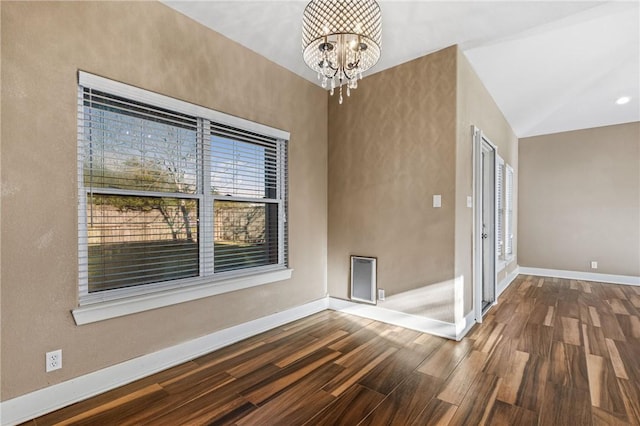 spare room featuring vaulted ceiling, a chandelier, and hardwood / wood-style flooring