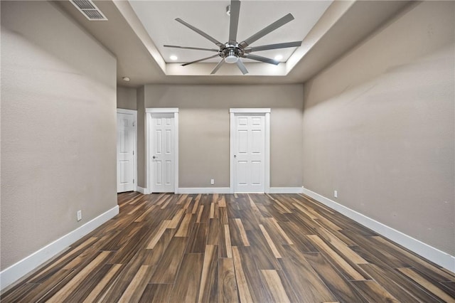 spare room featuring ceiling fan, a tray ceiling, and dark hardwood / wood-style floors