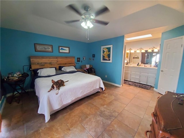bedroom featuring ensuite bath, baseboards, and a ceiling fan