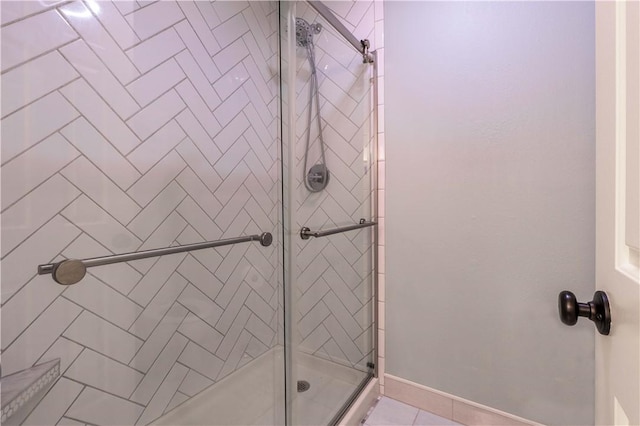 bathroom with tile patterned floors and a shower with door