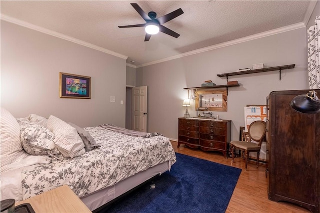 bedroom featuring ceiling fan, light hardwood / wood-style flooring, ornamental molding, and a textured ceiling