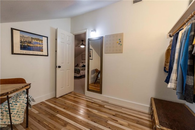 hall with lofted ceiling and light hardwood / wood-style flooring