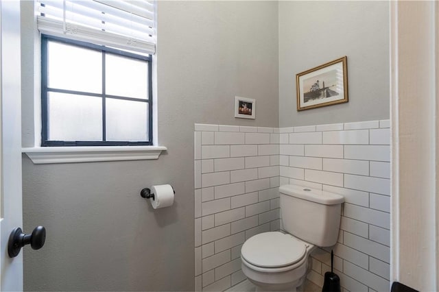 bathroom featuring tile walls and toilet