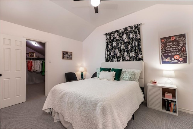 bedroom with ceiling fan, a spacious closet, vaulted ceiling, and carpet