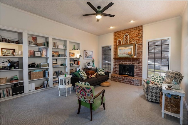 carpeted living room featuring ceiling fan, ornamental molding, a fireplace, and a textured ceiling