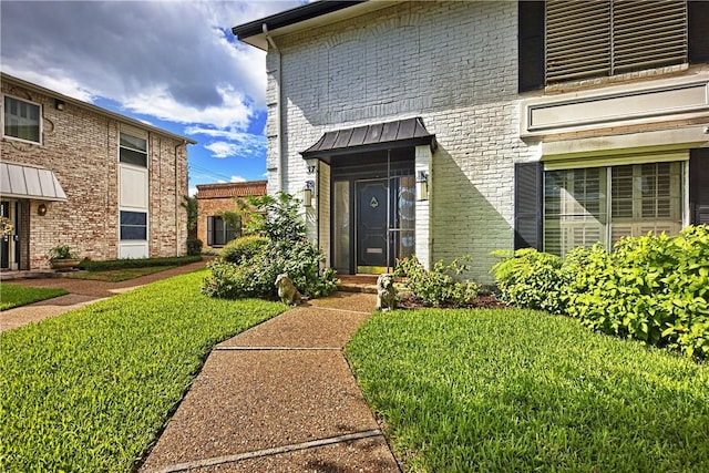 view of exterior entry featuring a yard