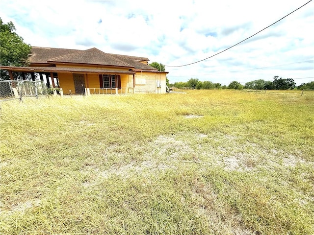 view of yard featuring fence and a porch