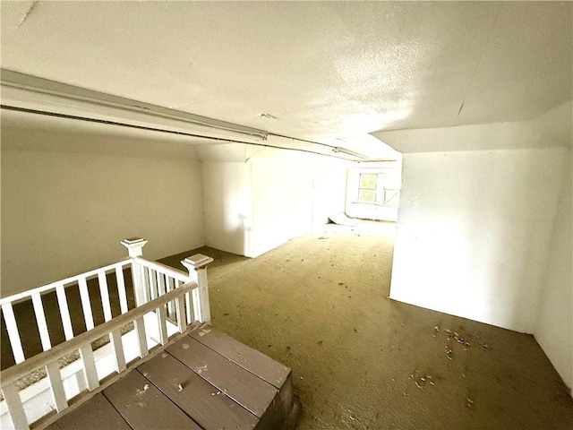hallway featuring a textured ceiling and an upstairs landing