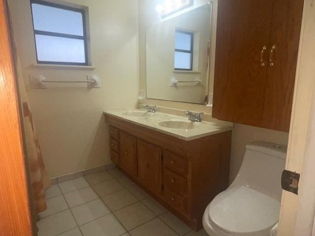 bathroom featuring vanity, a healthy amount of sunlight, tile patterned floors, and toilet