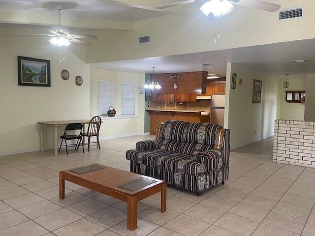 living room featuring light tile patterned floors, vaulted ceiling, and ceiling fan