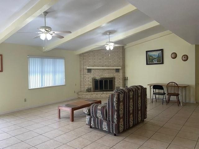 tiled living room with ceiling fan, lofted ceiling with beams, and a brick fireplace