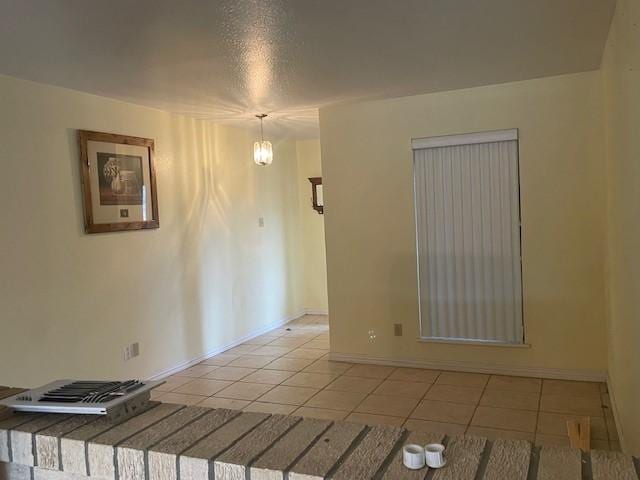 spare room with light tile patterned flooring and an inviting chandelier