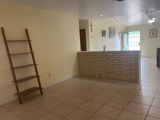 tiled spare room featuring lofted ceiling and ceiling fan