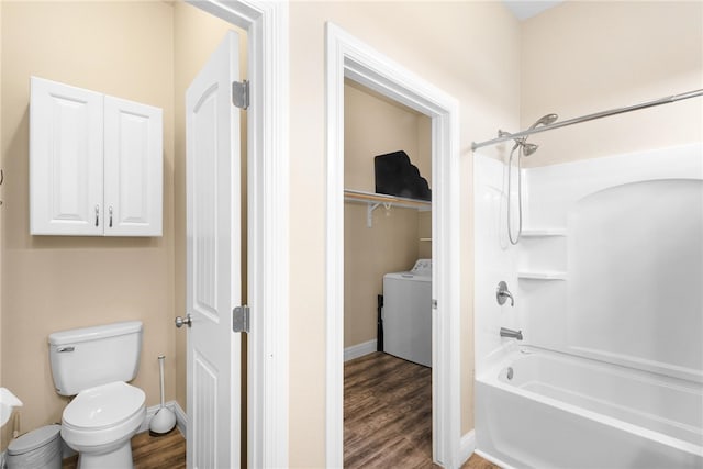 bathroom with washer / clothes dryer, hardwood / wood-style flooring, toilet, and bathtub / shower combination