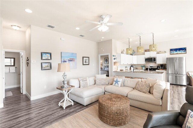 living room featuring light wood-type flooring and ceiling fan