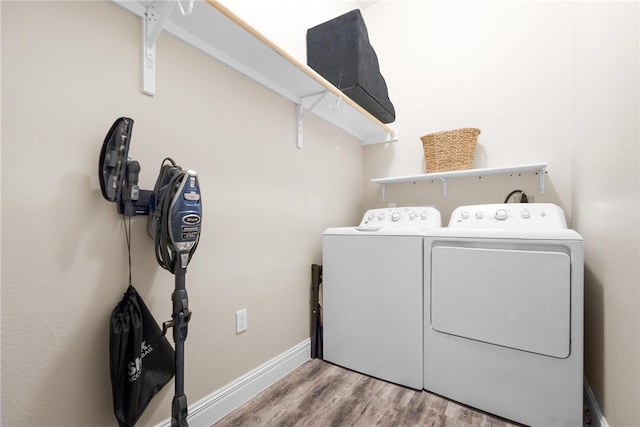 laundry area with washing machine and clothes dryer and light hardwood / wood-style floors