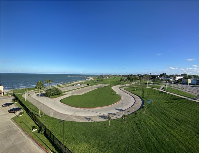 view of home's community with a water view and a lawn