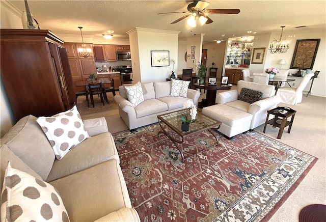 carpeted living room with ceiling fan with notable chandelier, a textured ceiling, and ornamental molding