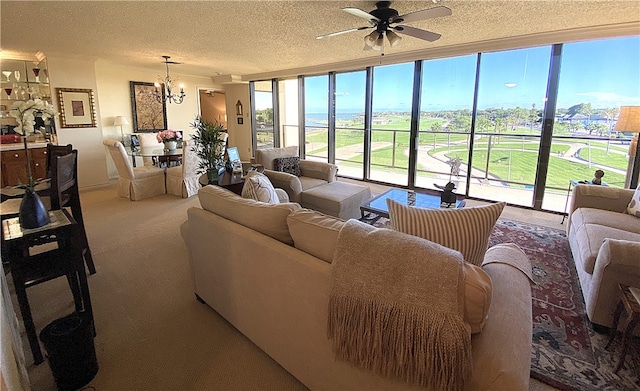 carpeted living room featuring ceiling fan with notable chandelier and a textured ceiling