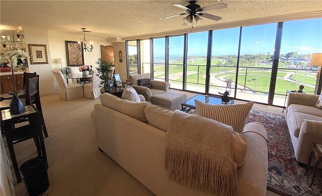 1400 Ocean Dr Unit 503-C, Corpus Christi, TX 78404 - carpeted living area featuring a ceiling fan, a chandelier, a textured ceiling, and a wall of windows