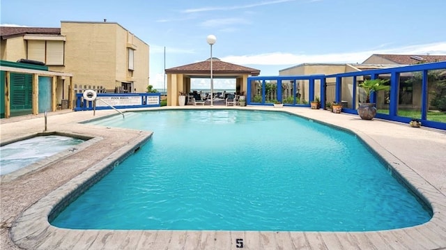 view of pool with a patio and a hot tub