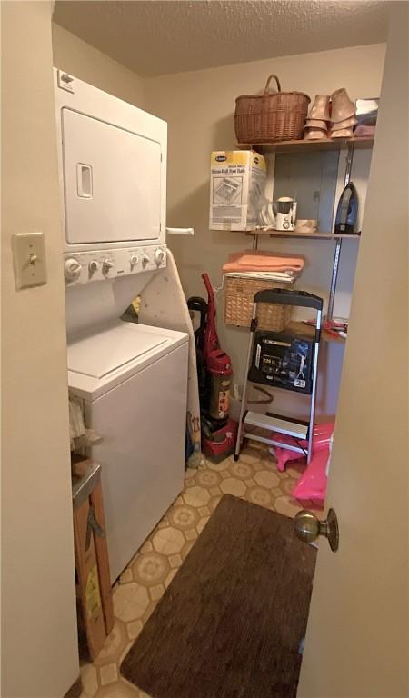 1400 Ocean Dr Unit 503-C, Corpus Christi, TX 78404 - washroom featuring stacked washer and clothes dryer, tile patterned floors, and a textured ceiling