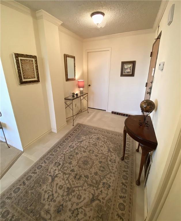 1400 Ocean Dr Unit 503-C, Corpus Christi, TX 78404 - hallway featuring a textured ceiling, crown molding, and light tile patterned floors