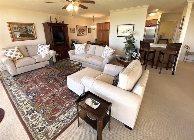 carpeted living room featuring ornamental molding, ceiling fan with notable chandelier, and a textured ceiling