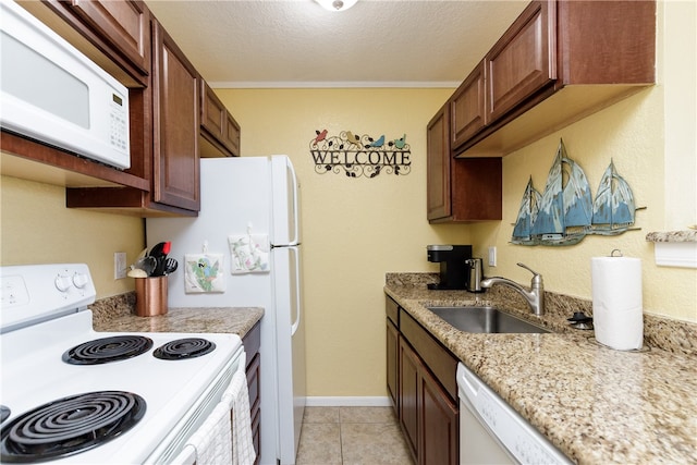 kitchen featuring white appliances, a textured ceiling, sink, and light tile patterned flooring