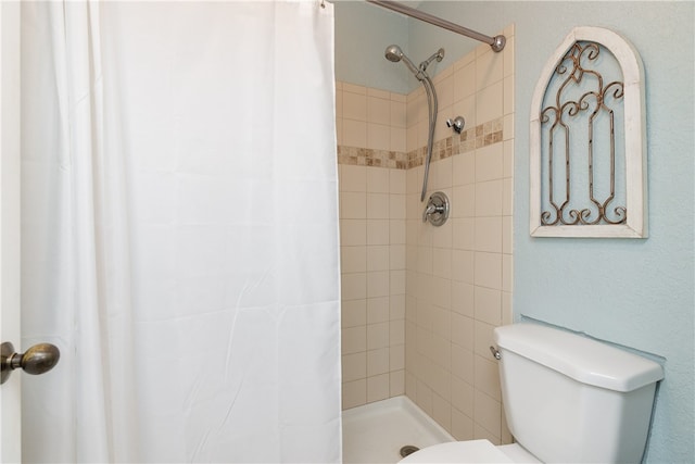 bathroom featuring walk in shower and toilet