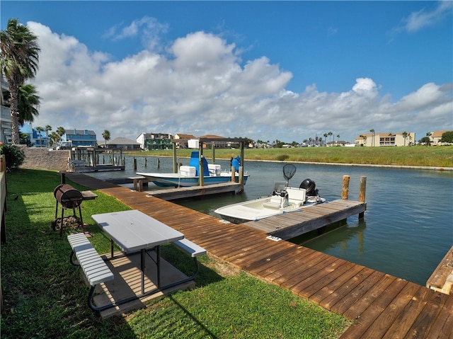 dock area with a water view and a lawn