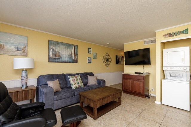 living room with ornamental molding, a textured ceiling, and stacked washer / dryer