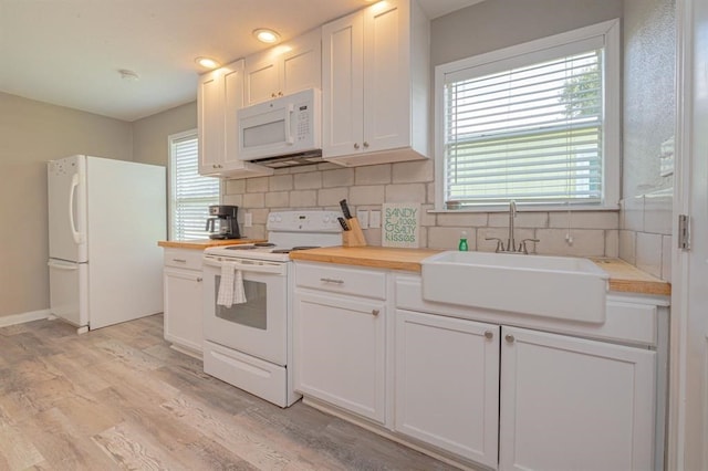 kitchen with wood counters, white appliances, sink, tasteful backsplash, and white cabinetry