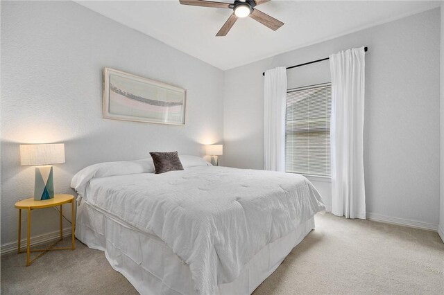 carpeted bedroom featuring baseboards and a ceiling fan