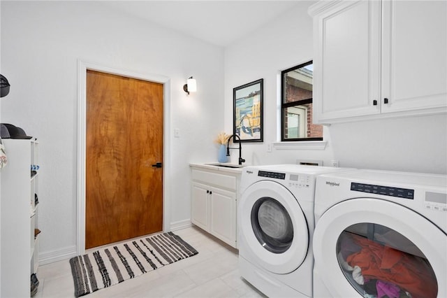 laundry area featuring a sink, cabinet space, washing machine and clothes dryer, and baseboards