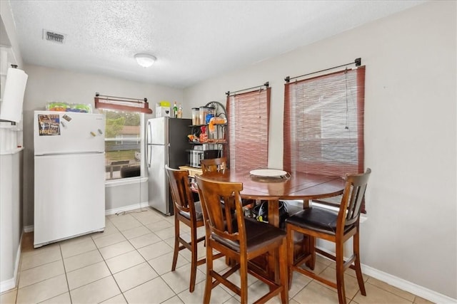 4622 Bluebelle Ln, Corpus Christi, TX 78416 - dining room with baseboards, a textured ceiling, and light tile patterned floors