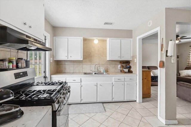 4622 Bluebelle Ln, Corpus Christi, TX 78416 - kitchen featuring gas stove, a sink, under cabinet range hood, light countertops, and white cabinets