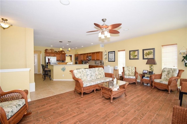 living area with light wood-style floors, recessed lighting, ceiling fan, and baseboards