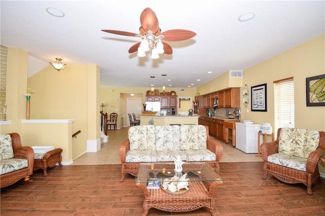 living area featuring visible vents, baseboards, light wood-style flooring, and recessed lighting