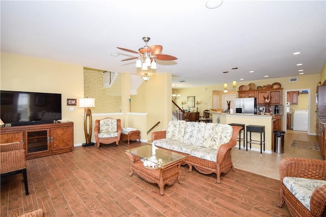 living room with light wood-style floors, recessed lighting, visible vents, and stairway